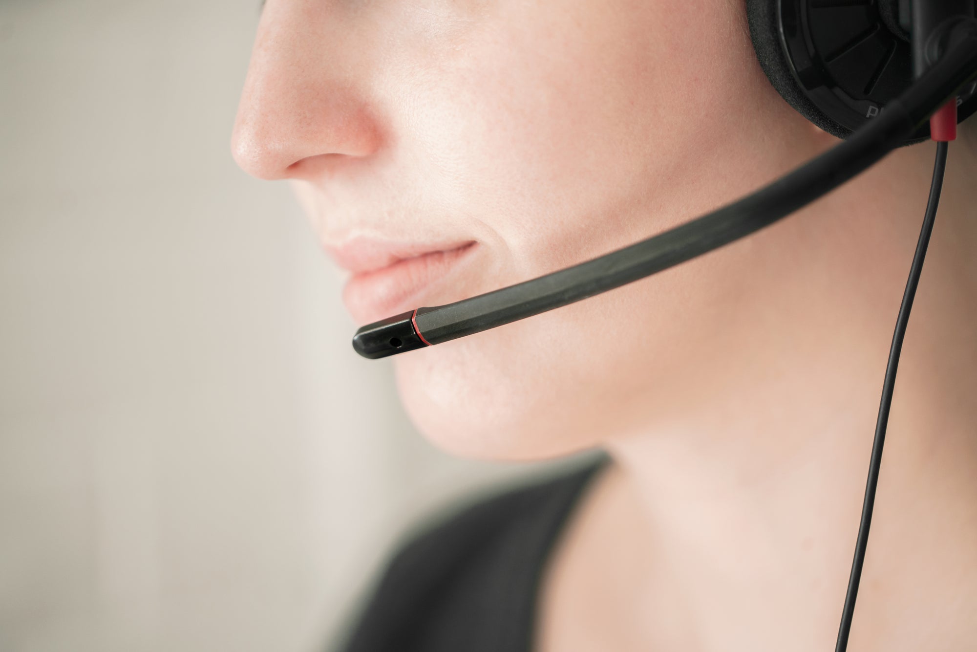 Close-up of a woman wearing a headset microphone, symbolizing customer support or live assistance.
